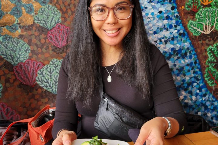 a woman sitting at a table with a plate of food