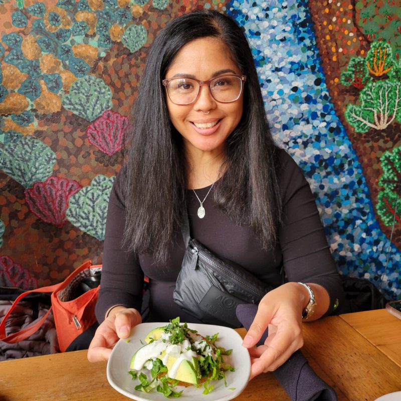 a woman sitting at a table with a plate of food