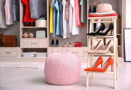 Pink ottoman chair and stand with shoes in dressing room