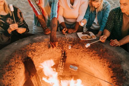 Friends roasting marshmallows for s'mores