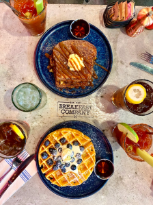 A waffle and french toast served with Bloody Mary's for brunch