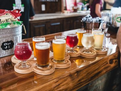 Multiple wooden platters with samples of assorted beer, cider, and mead.