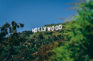 a view of the hollywood sign in summer with lush green trees and a clear blue sky