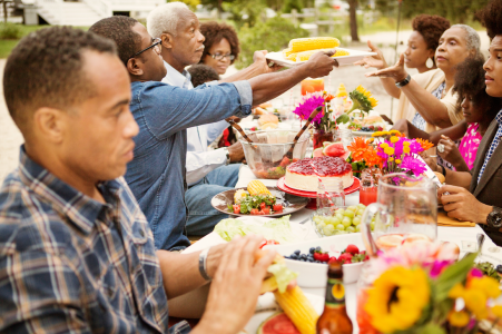 a large family sitting at a table eating food