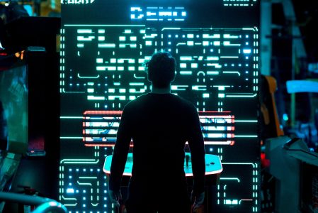 a man standing in front of a screen at an arcade