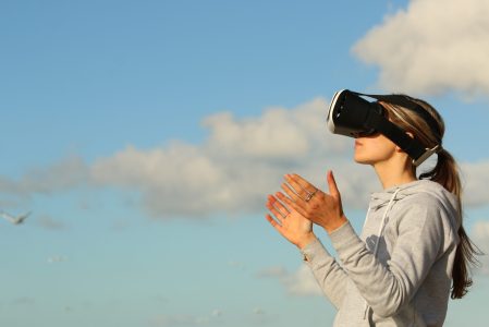 a woman using Virtual Reality goggles outdoors