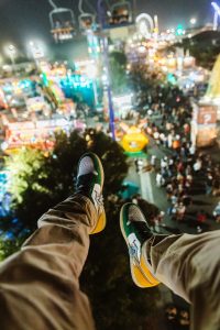 Person in Brown Pants and Black and White Sneakers with their legs dangling