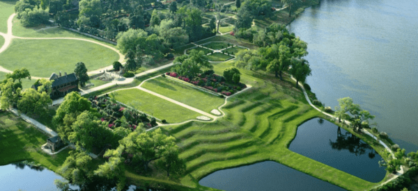 a garden with water in the background