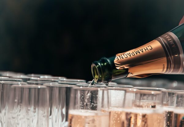 filling glasses with champagne and a black background
