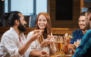 a group of people sitting at a table eating food