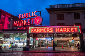 a store front at night with Pike Place Market in the background