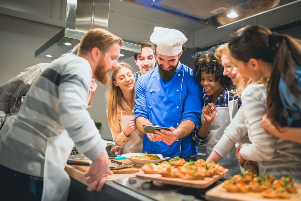 a group of people preparing food with a chef