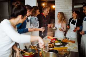 a group of people standing in a kitchen preparing food
