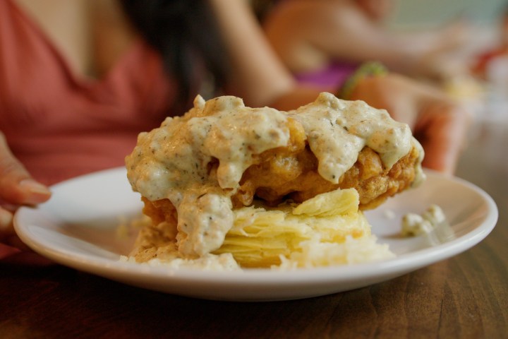 Close up of chicken, biscuits, and gravy on a plate