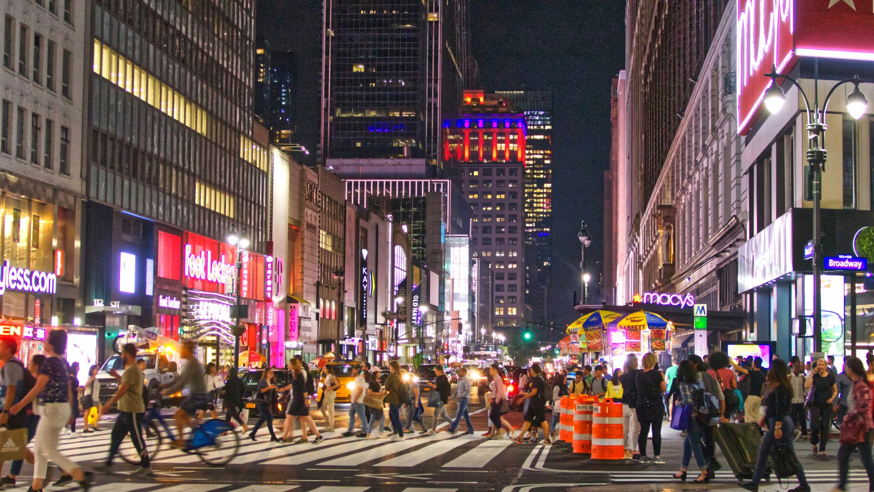 a group of people walking on a busy new york city street