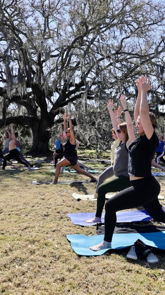 a group of people doing yoga in a park