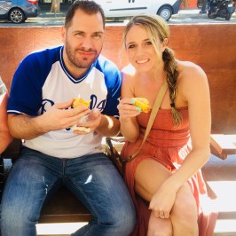 a man and a woman sitting in a chair talking on a cell phone