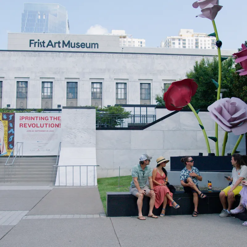 a person standing in front of a building with a stuffed animal
