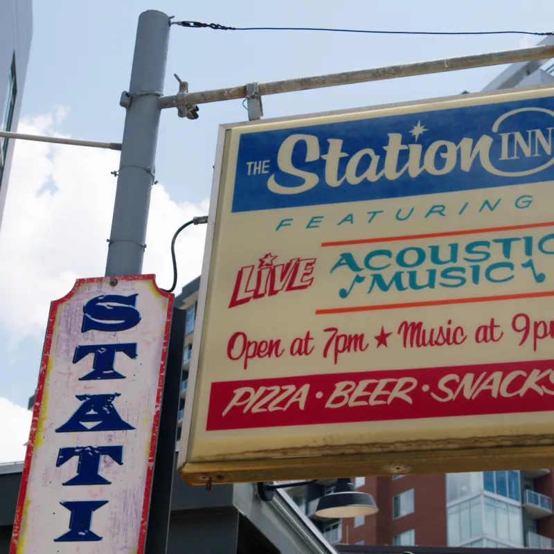 a sign hanging off the side of a building