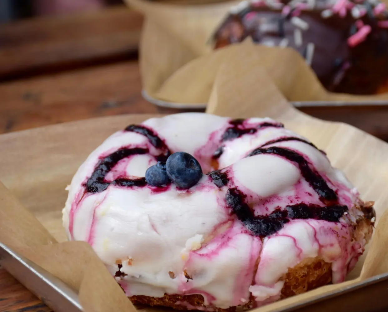 a close up of a blueberry donut on top of a wooden table