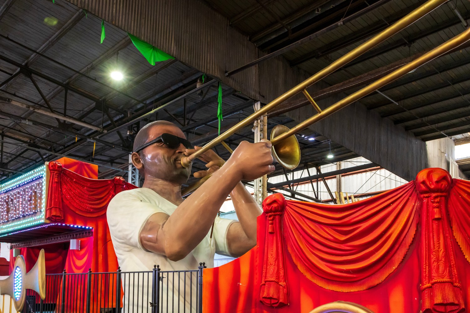 An exhibit of an african american man with glasses playing the trumpet at The New Orleans African American Museum