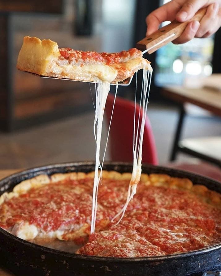 a close up of a person cutting a piece of pizza