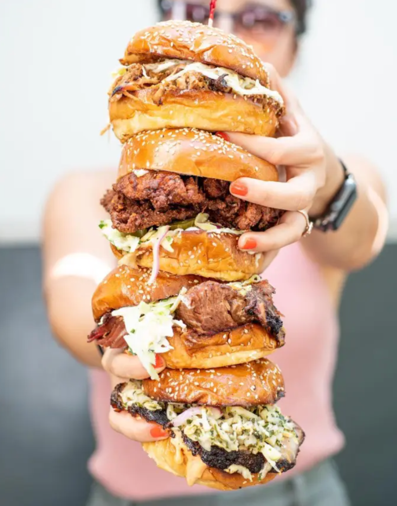 hands holding a stack of delicious sandwiches