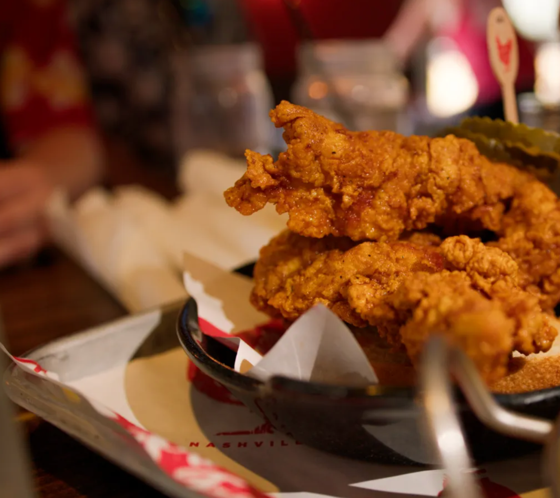 a close up of a plate of Nashville hot chicken on a table