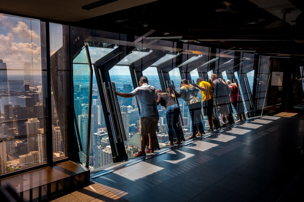 Tilting glass at John Hancock Center observation area overlooking a full 360 of Downtown Chicago