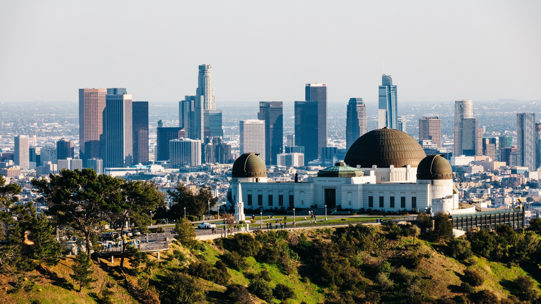 From downtown Los Angeles, the view over Griffith Observatory showcases an enchanting cityscape that dazzles with its twinkling lights against the night sky,