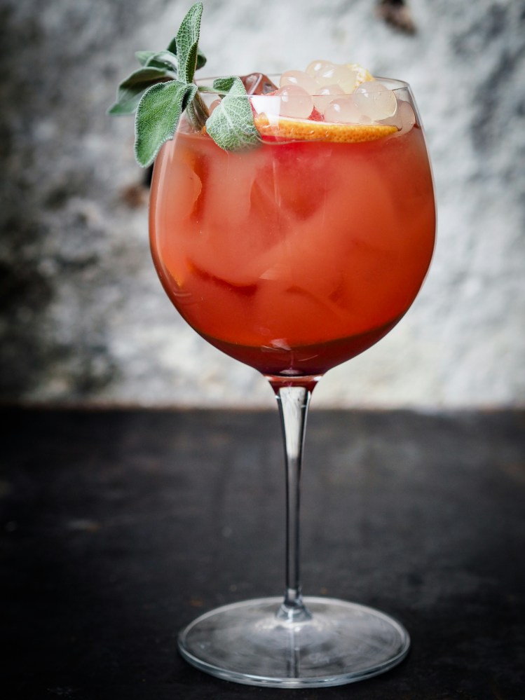 a close up of a holiday cocktail in a wine glass