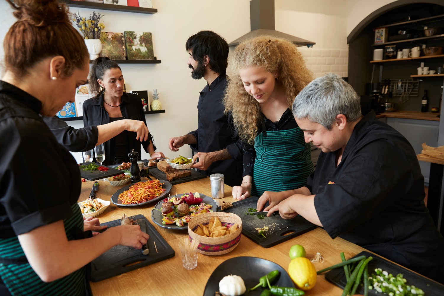 A group of people different ages and races taking a cooking class