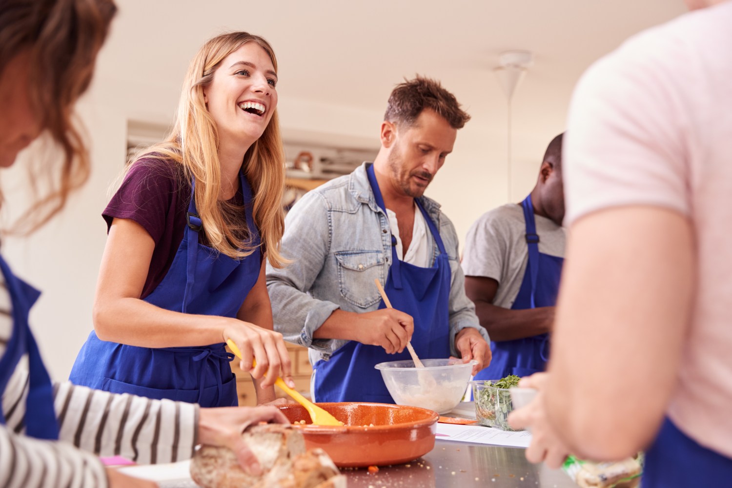 Students of the kitchen preparing ingredients for dish as part of Group Cooking Class in New York