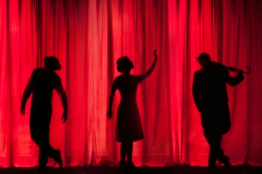 a group of people standing in front of a curtain