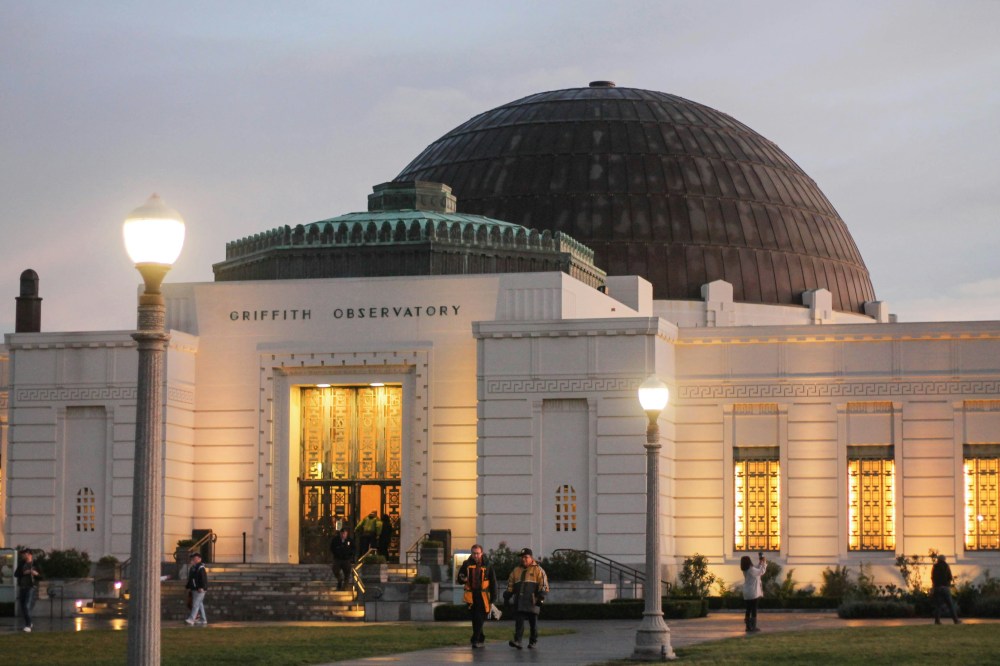 a group of people standing in front of Griffith Observatory