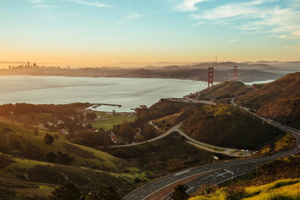 Golden Gate Bridge with San Francisco skyline at sunset in the background.