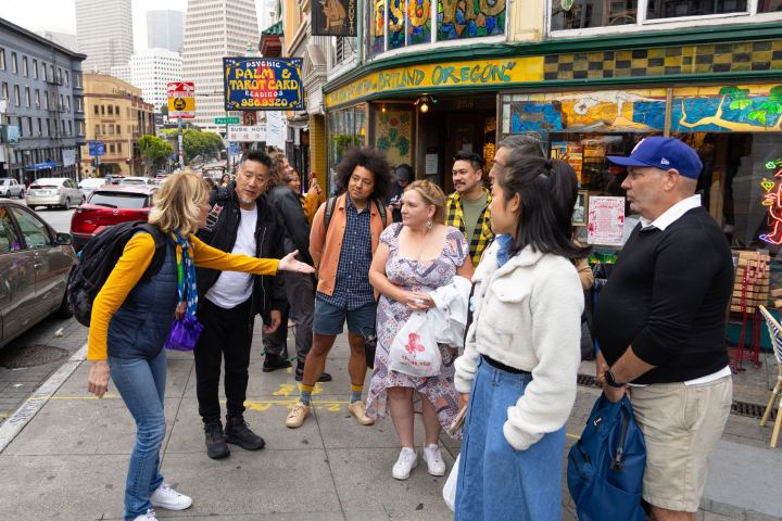 Group of people interacting on a colorful city street corner.